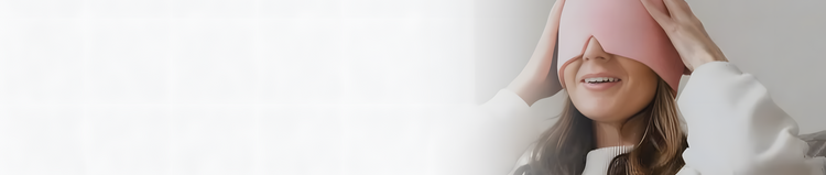 Person wearing a pink sleep mask indoors with a neutral background